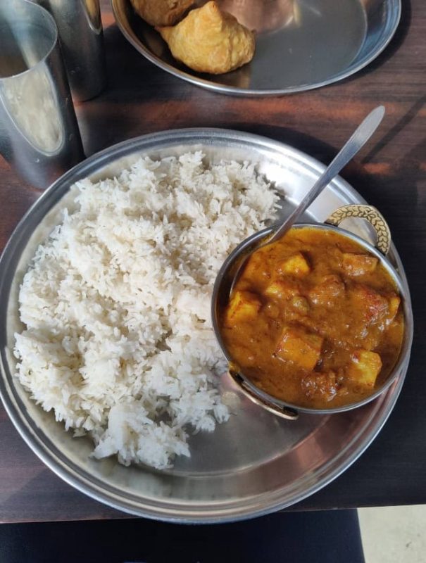 Best Restaurants In Pokhara: Cafes, Cheap Eats & Local Food 35 a plate of rice with a bowl of paneer butter masala at Spice Nepal Pure Vegetarian Restaurant in Pokhara