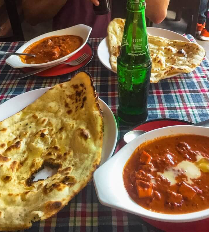 Best Restaurants In Pokhara: Cafes, Cheap Eats & Local Food 27 two dishes of butter paneer and butter chicken with two large naan breads from Kabab King in Pokhara