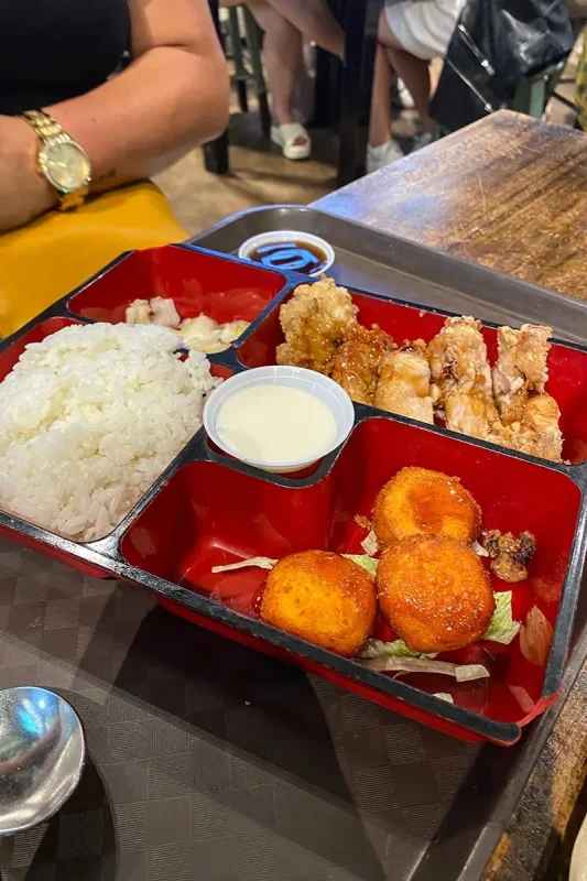 Japanese food dishes up on a red tray at Lau Pa Sat Singapore