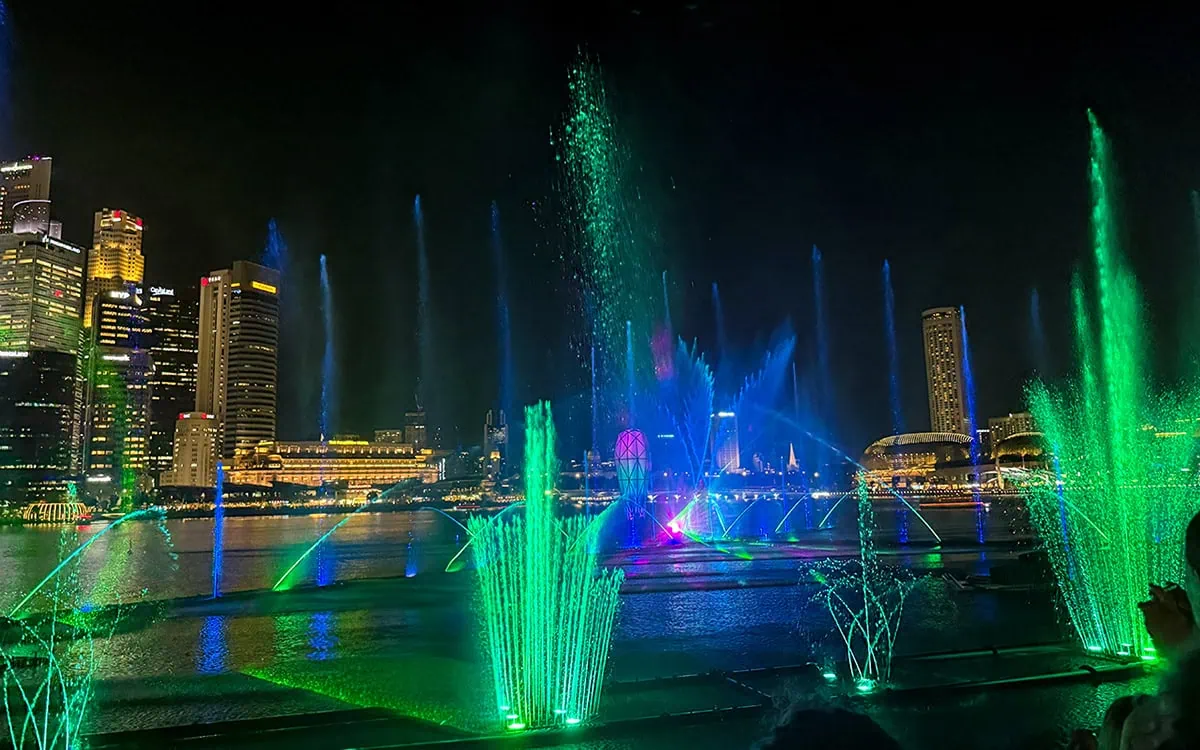 Spectra Light Show Singapore: Times, Best Views & Tips 12 The Spectra Light Shows fountains on full display with the Singapore skyline behind