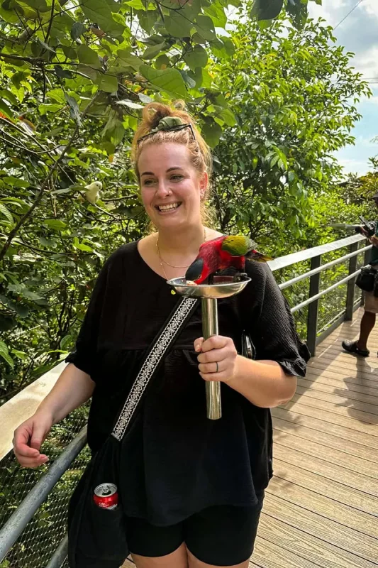 Tasha Amy walking around the Lory Loft in Bird Paradise with a Black Capped Lory