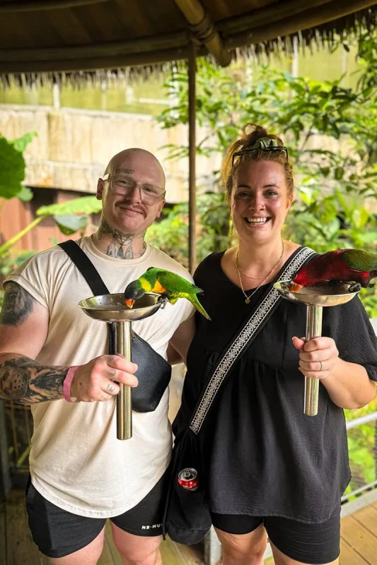 Tasha Amy and a man holding bowls at lorikeet feeding in Bird Paradise Singapore
