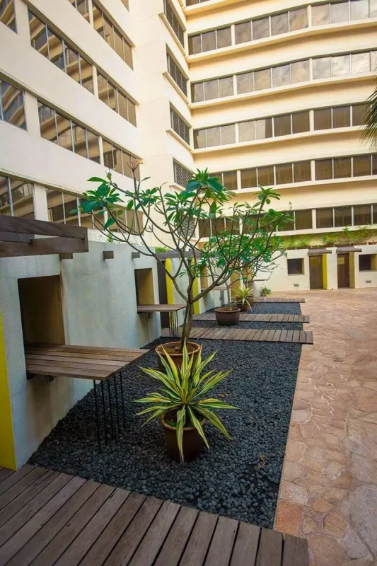 Furama RiverFront Review: What It’s Really Like To Stay Here 6 Outdoor courtyard walkway lined with potted plants and wooden decks at Furama RiverFront