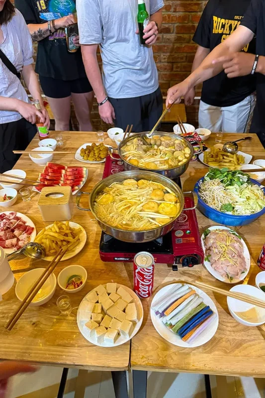 Group hotpot dinner with tofu, vegetables and shared dishes in Dong Van