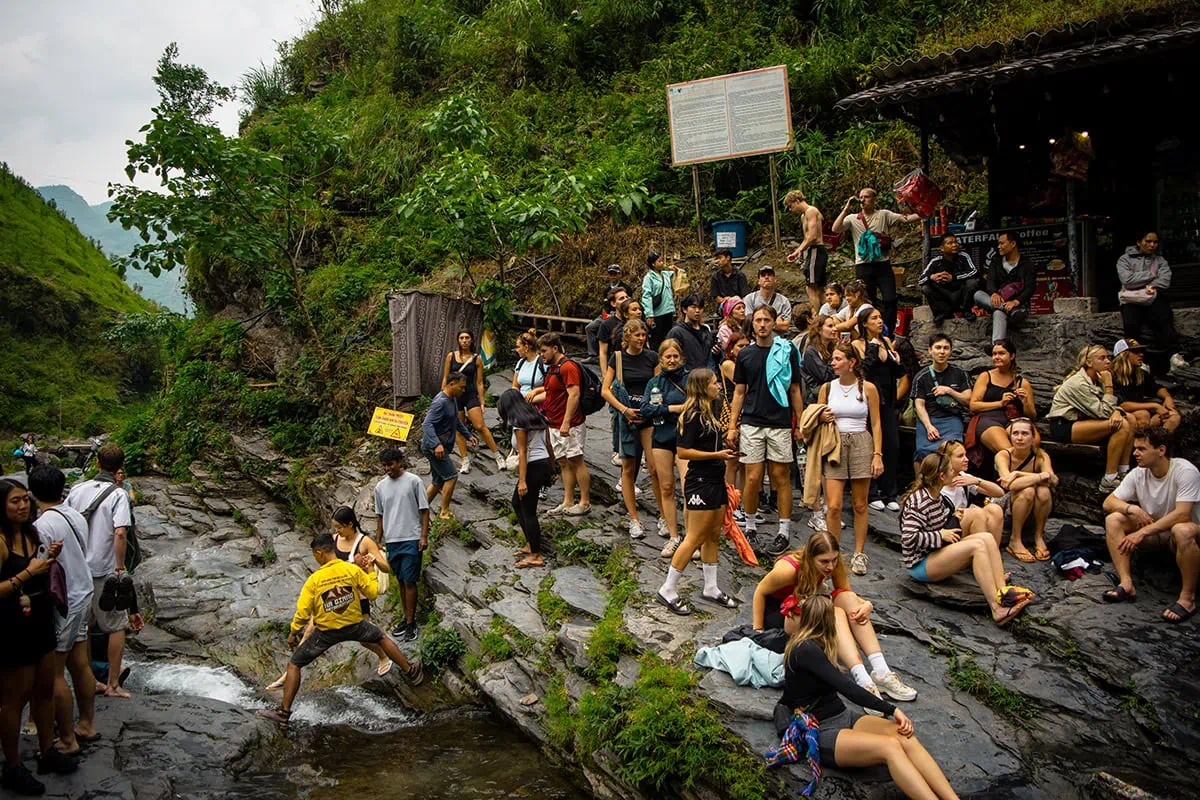 Crowds gathered beside the swimming area at Du Gia Waterfall