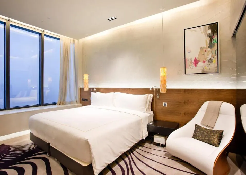 Where To Stay In Singapore: The 6 Best Areas & Hotels 29 Modern guest room with a double bed and large windows at One Farrer Hotel in Singapore