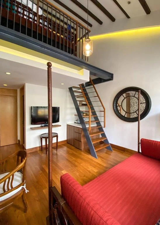 Where To Stay In Singapore: The 6 Best Areas & Hotels 34 Loft-style guest room with a wooden staircase and red bed at The Sultan hotel in Singapore