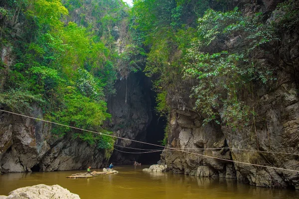 Bamboo raft floating outside the rocky entrance of Hang Tham Lin Cave in Ha Giang