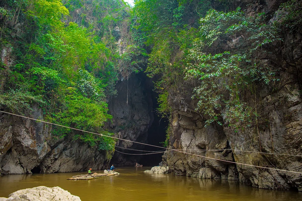 Bamboo raft floating outside the rocky entrance of Hang Tham Lin Cave in Ha Giang