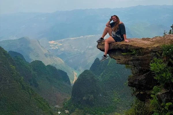 Tasha sitting on Death Rock above the mountain valley along the Ma Pi Leng Skywalk