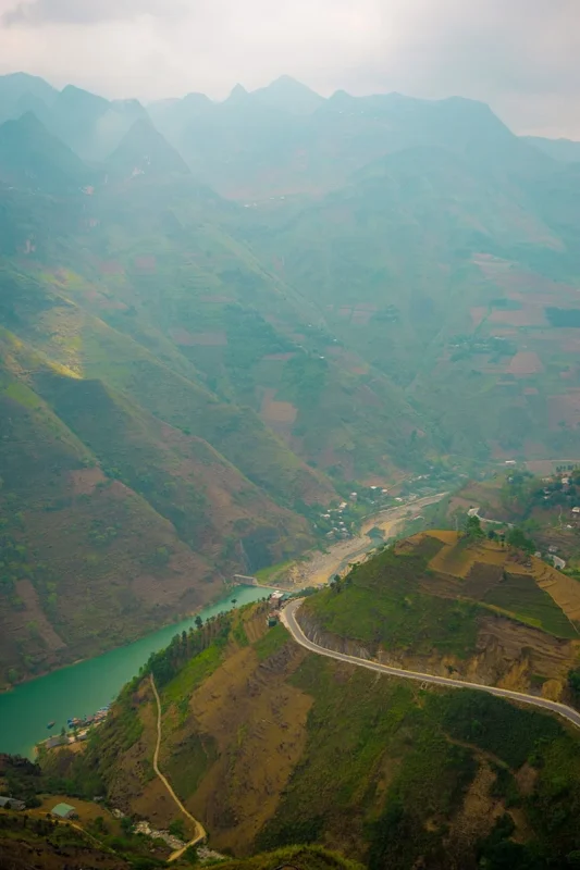 Nho Que River Boat Ride: Visiting While On The Ha Giang Loop 63 Nho Que River and winding mountain road viewed from high above the valley