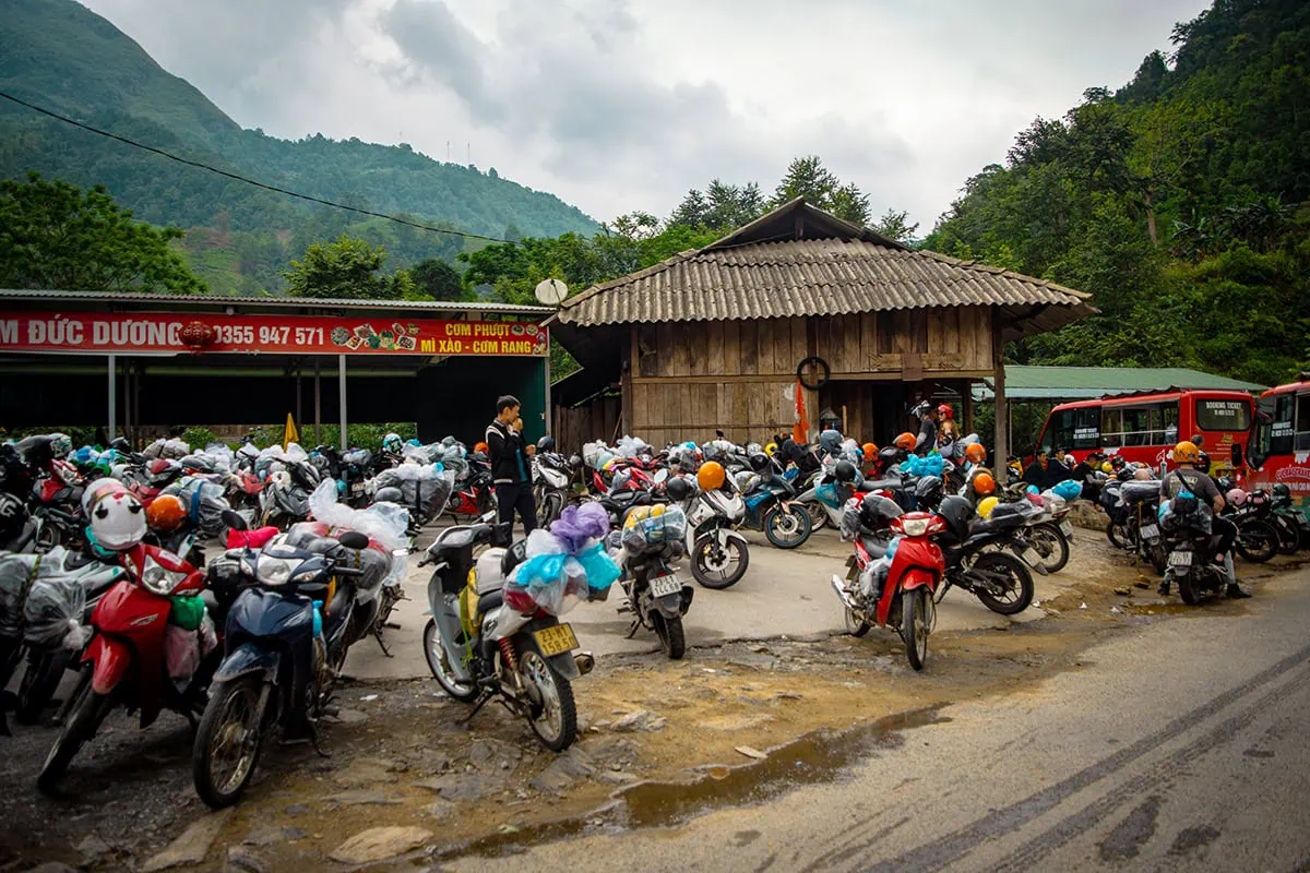 Crowded motorbike parking area outside Du Gia Waterfall in Ha Giang