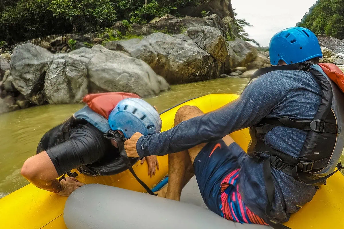 White Water Rafting In La Ceiba: My Experience On The Cangrejal River 35 Two helmeted rafters bracing inside a yellow raft on the Cangrejal River