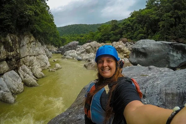 Tasha wearing a helmet and life jacket beside the about to go white water rafting in La Ceiba Honduras
