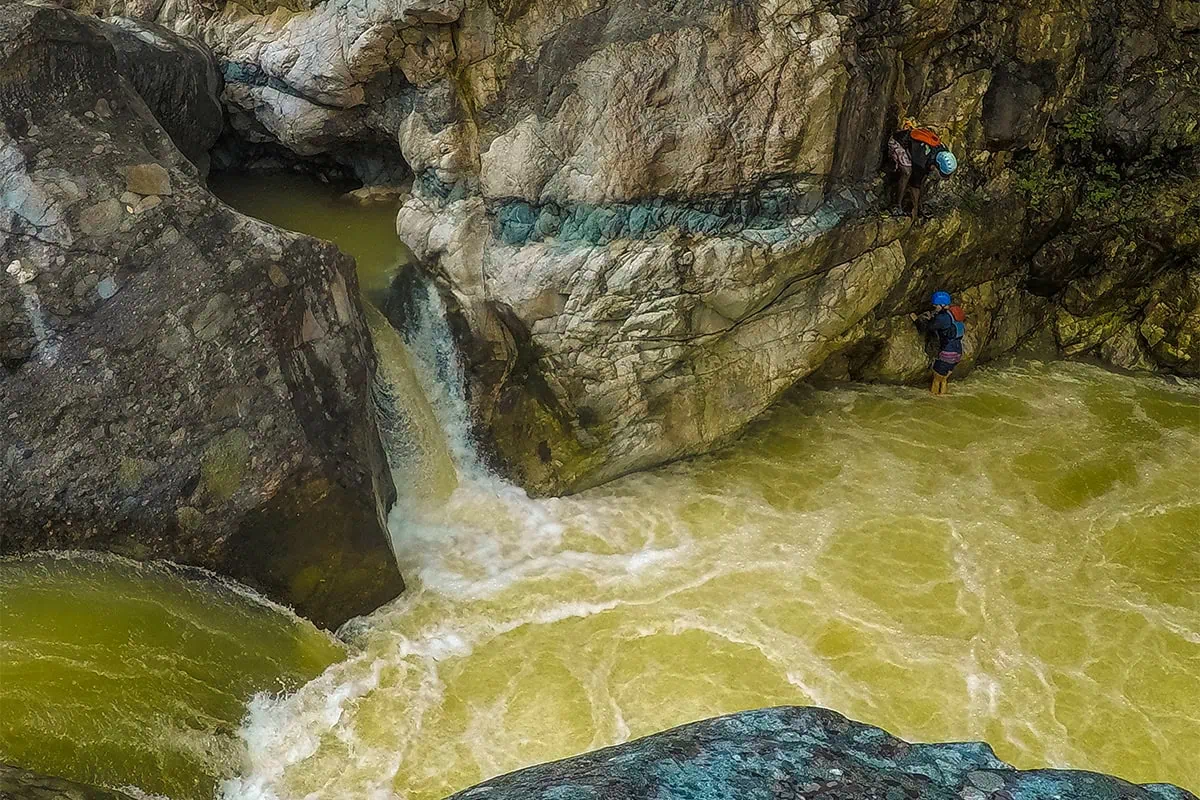 White Water Rafting In La Ceiba: My Experience On The Cangrejal River 25 Two travelers canyoning beside a small waterfall in the rocky Cangrejal River