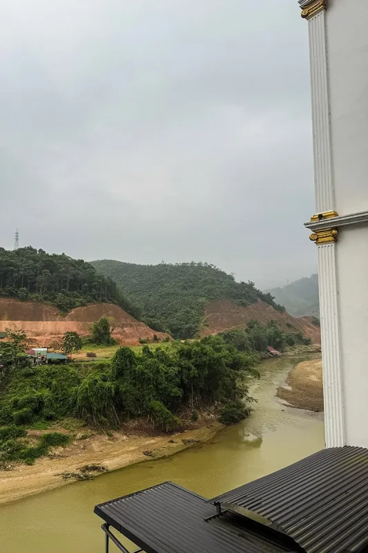 Best Hostels In Ha Giang: Where To Stay Before The Loop 67 River and wooded hills viewed from Silk River Hotel Ha Giang beneath an overcast sky