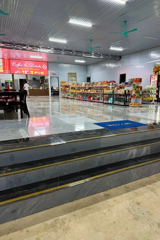Ha Giang To Ha Long Bay: My VIP Sleeper Bus Experience (2026) 67 Roadside rest stop with shelves of snacks, a drinks counter and indoor seating