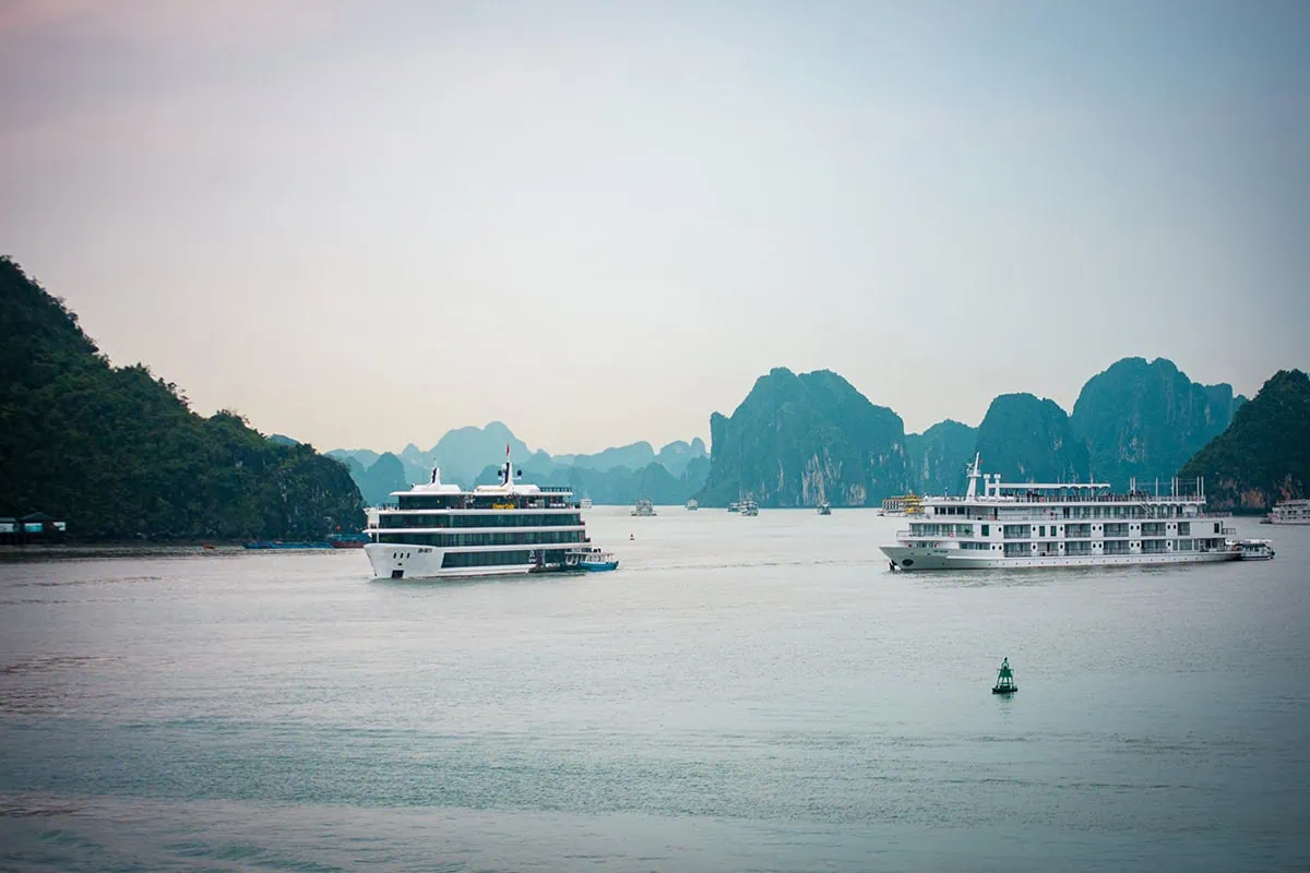 Ha Giang To Ha Long Bay: My VIP Sleeper Bus Experience (2026) 71 Cruise boats on Ha Long Bay surrounded by limestone islands beneath an overcast sky