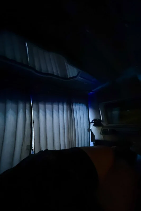 Ha Giang To Ha Long Bay: My VIP Sleeper Bus Experience (2026) 62 Dimly lit sleeper bus cabin with the privacy curtain drawn beside the bed