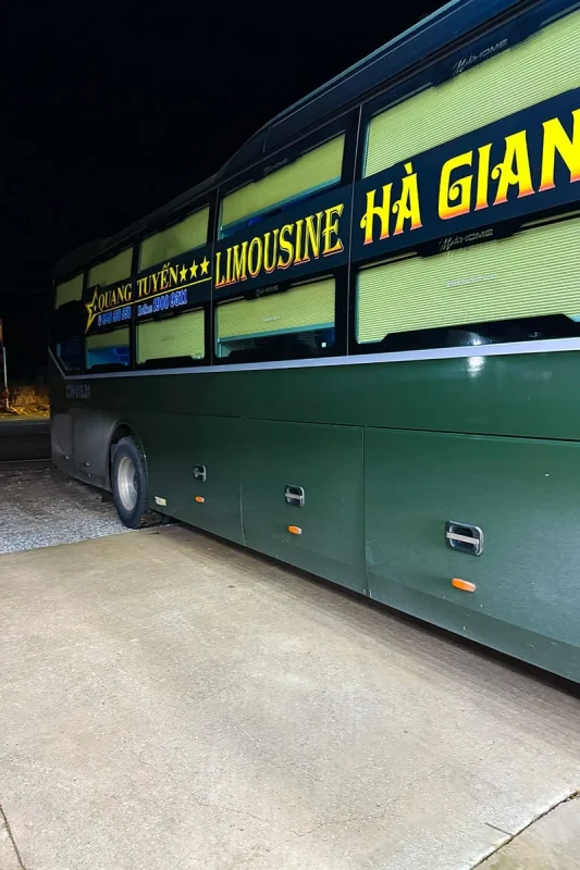 Ha Giang To Ha Long Bay: My VIP Sleeper Bus Experience (2026) 61 Green Quang Tuyen sleeper bus with two rows of closed window blinds, parked at night