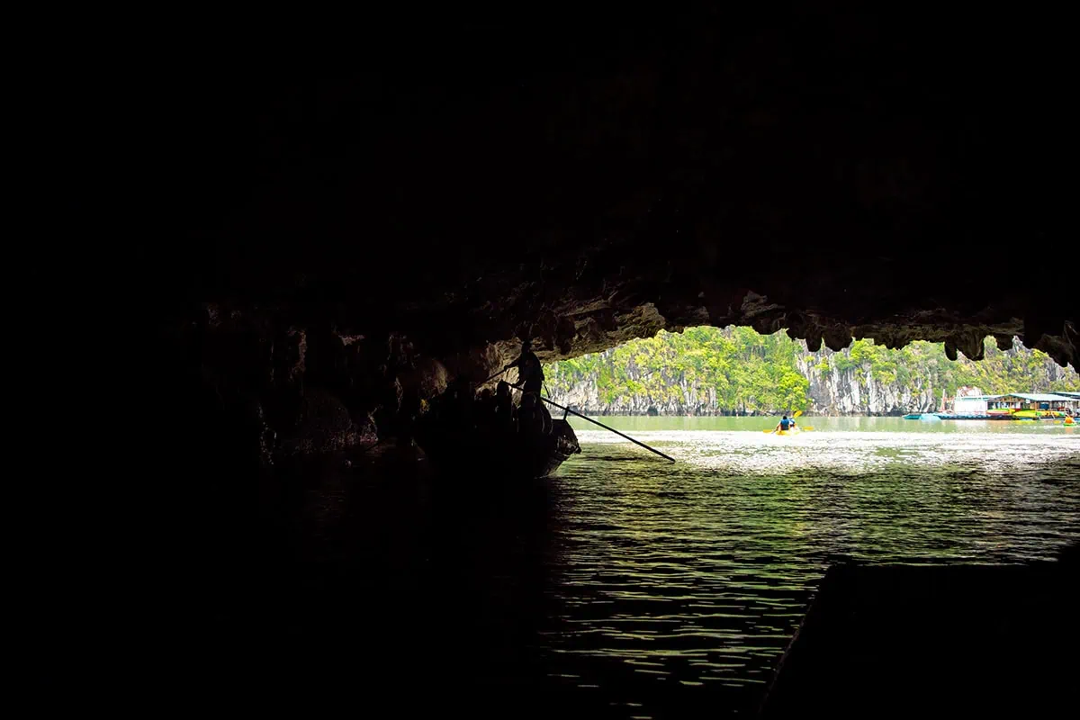 Luon Cave Ha Long Bay: Is It Worth Visiting? 73 View from inside dark Luon Cave toward daylight, a kayak and the floating boat station